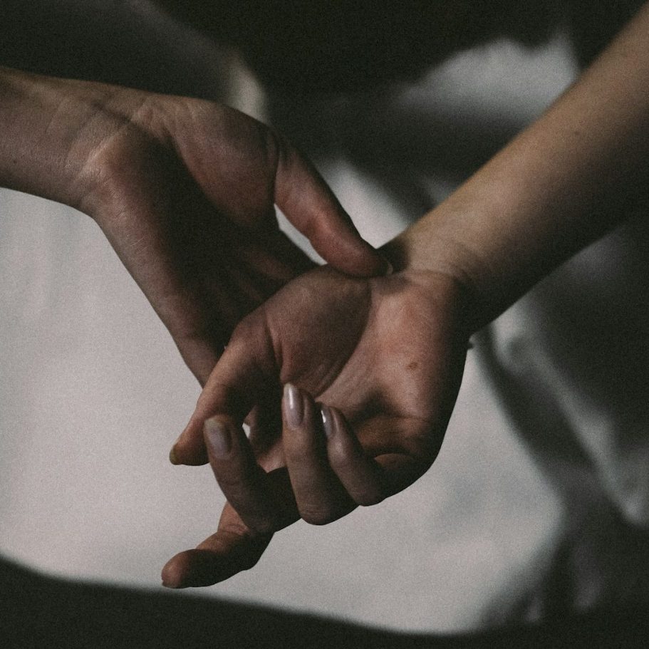 Sexualberatung Zwei Hände, eine greift die andere, symbolisieren Intimität.